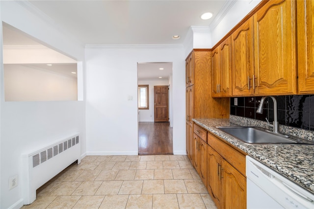 kitchen with decorative backsplash, a sink, radiator, dishwasher, and brown cabinetry