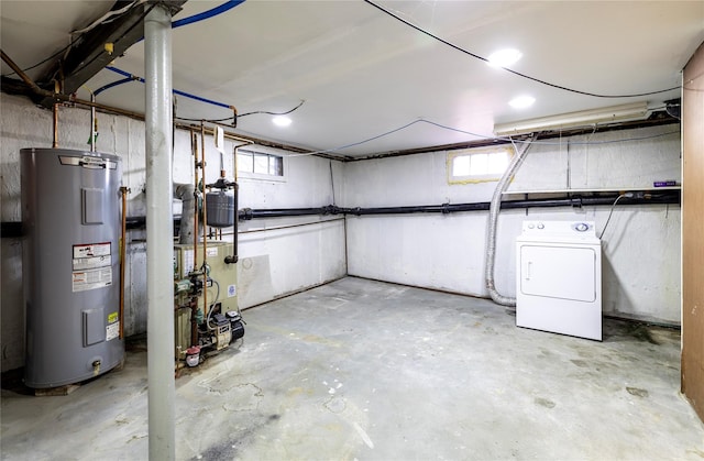 basement with a heating unit, a wealth of natural light, electric water heater, and washer / clothes dryer