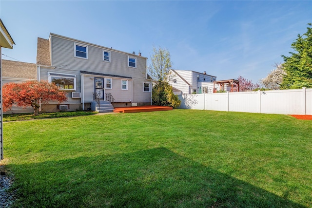 rear view of house featuring fence and a lawn