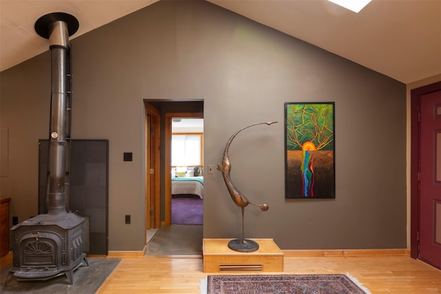 corridor featuring high vaulted ceiling, baseboards, and light wood-style floors
