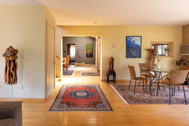 hallway with baseboards, light wood-style floors, and stairway