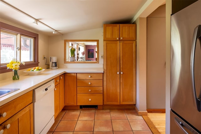 kitchen featuring light tile patterned floors, dishwasher, track lighting, light countertops, and freestanding refrigerator