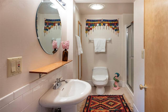 full bathroom with toilet, tile patterned floors, a sink, and a stall shower