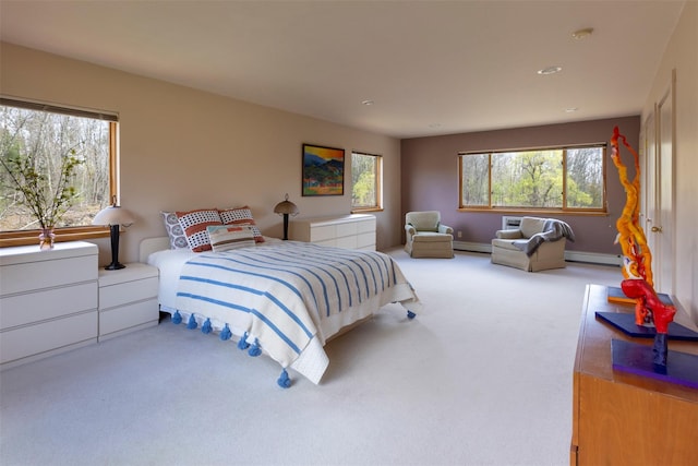 carpeted bedroom featuring a baseboard heating unit and baseboards