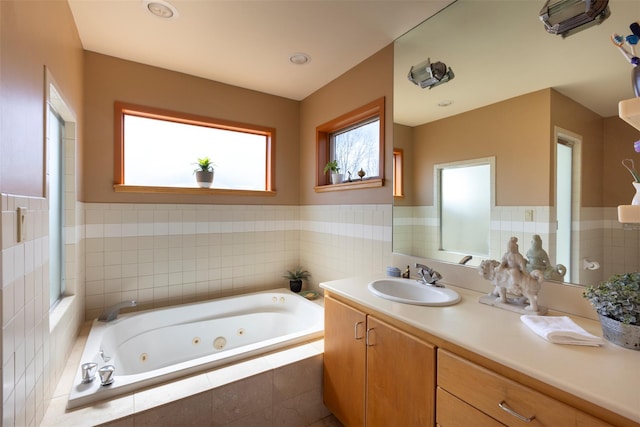 bathroom featuring a wainscoted wall, a jetted tub, and vanity