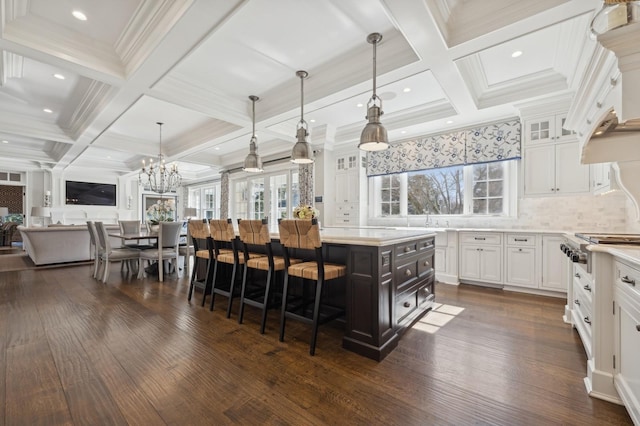 kitchen with white cabinetry, coffered ceiling, light countertops, and plenty of natural light