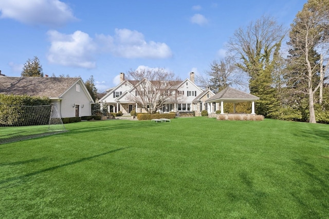 shingle-style home featuring a gazebo and a chimney