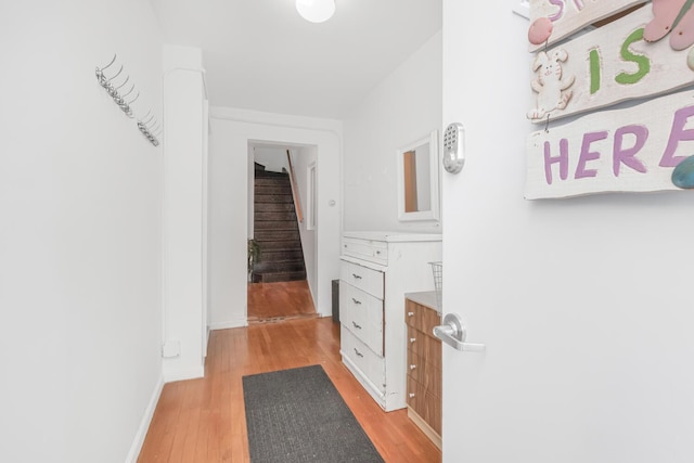 327 E 241st St, Bronx, NY 10470 - corridor featuring baseboards, light wood-style floors, and stairway