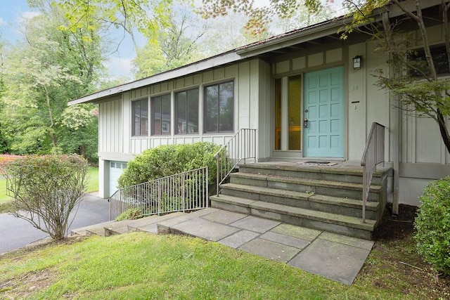 14 Wesley Ct, Congers, NY 10920 - doorway to property with board and batten siding, a garage, and driveway