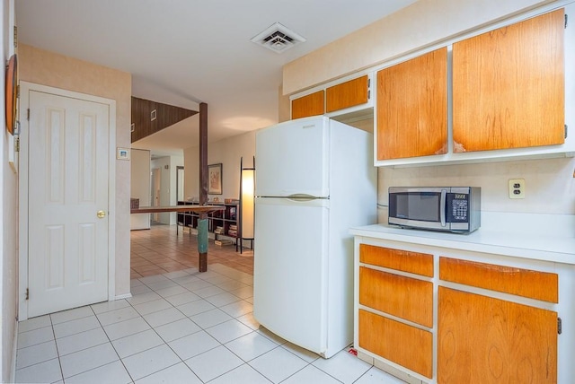 14 Wesley Ct, Congers, NY 10920 - kitchen featuring freestanding refrigerator, stainless steel microwave, light countertops, and light tile patterned floors