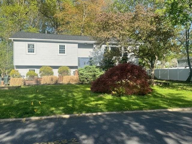 view of front facade featuring a front lawn and fence