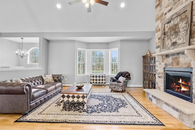 12 Hill Rd, Washingtonville, NY 10992 - living room with wood finished floors, ceiling fan with notable chandelier, a stone fireplace, and a baseboard radiator