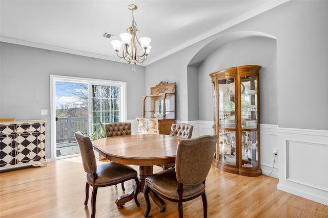 12 Hill Rd, Washingtonville, NY 10992 - dining space featuring visible vents, a wainscoted wall, arched walkways, light wood finished floors, and a notable chandelier