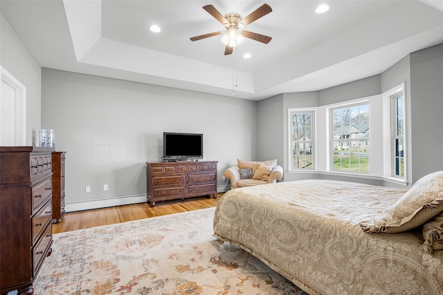 12 Hill Rd, Washingtonville, NY 10992 - bedroom featuring recessed lighting, a tray ceiling, a ceiling fan, baseboard heating, and wood finished floors