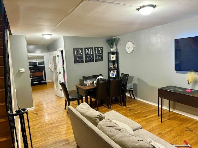 living room featuring wood finished floors, stairs, and baseboards
