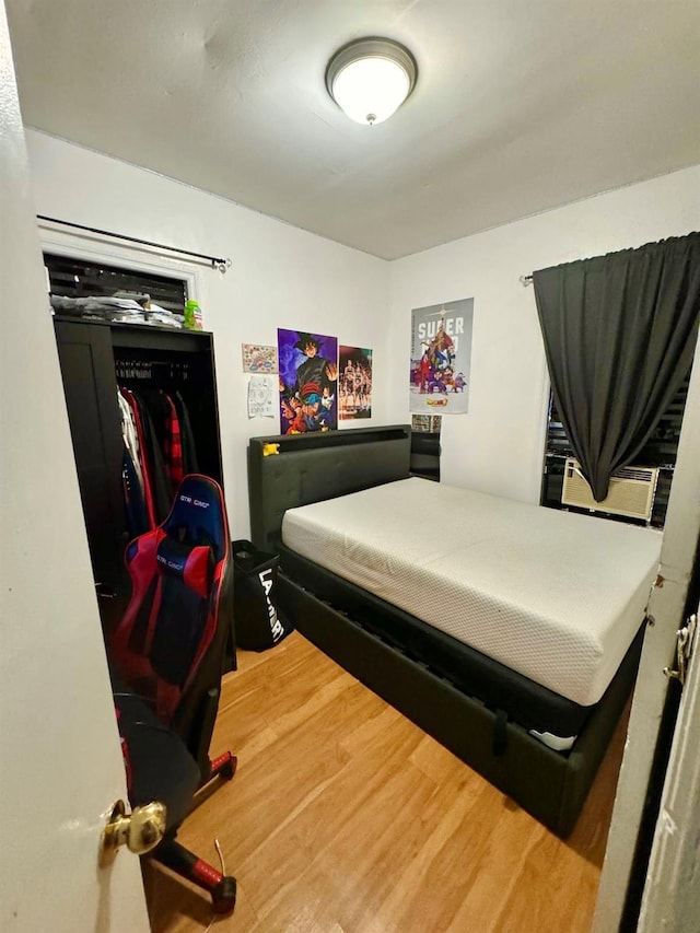 bedroom featuring wood finished floors and cooling unit