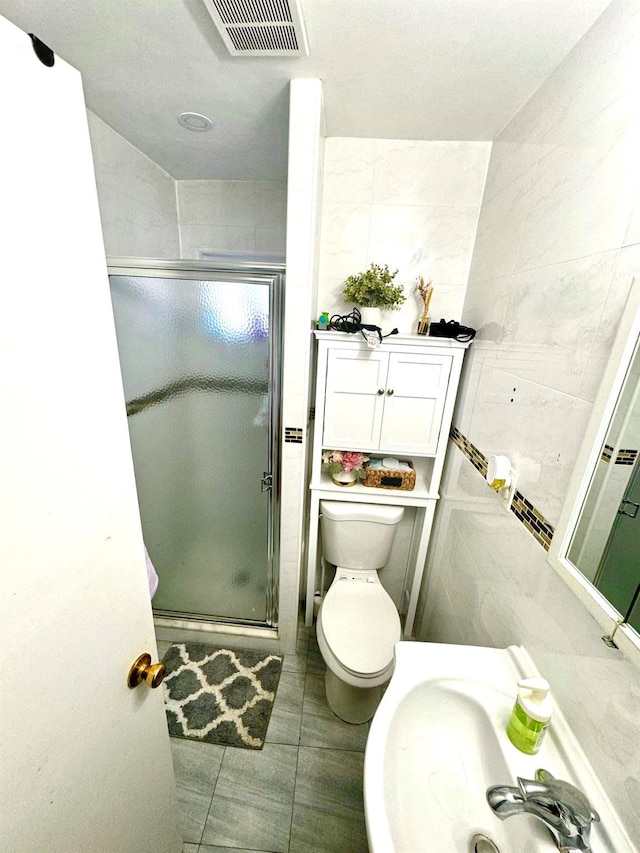 bathroom featuring toilet, visible vents, a shower stall, and tile walls