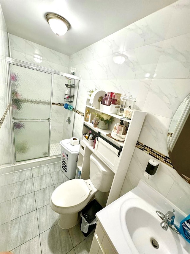full bathroom featuring tile walls, a stall shower, toilet, and vanity