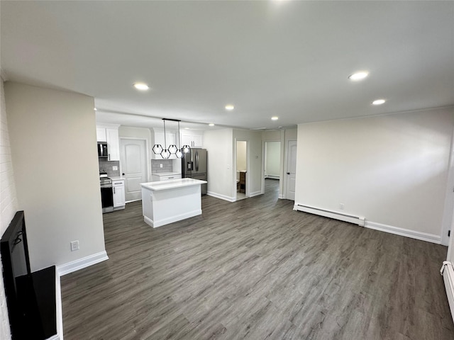 unfurnished living room with a baseboard heating unit, baseboard heating, dark wood-style flooring, and recessed lighting