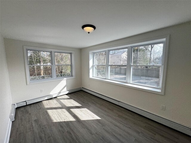 unfurnished room featuring wood finished floors and a baseboard radiator