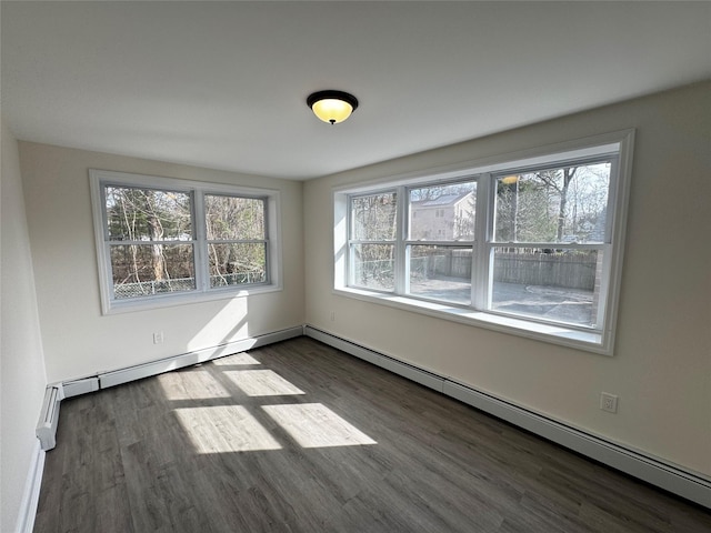 spare room with baseboard heating and wood finished floors