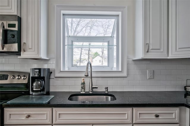 5 Cottonwood Ave, Port Jefferson Station, NY 11776 - kitchen featuring dark stone countertops, a sink, decorative backsplash, stainless steel range with electric cooktop, and white cabinetry