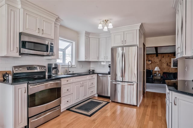 5 Cottonwood Ave, Port Jefferson Station, NY 11776 - kitchen featuring a sink, light wood-style floors, tasteful backsplash, appliances with stainless steel finishes, and white cabinetry