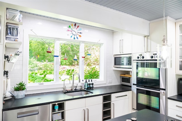 2 Spring Hollow Rd, Centerport, NY 11721 - kitchen featuring appliances with stainless steel finishes, dark countertops, backsplash, and white cabinets