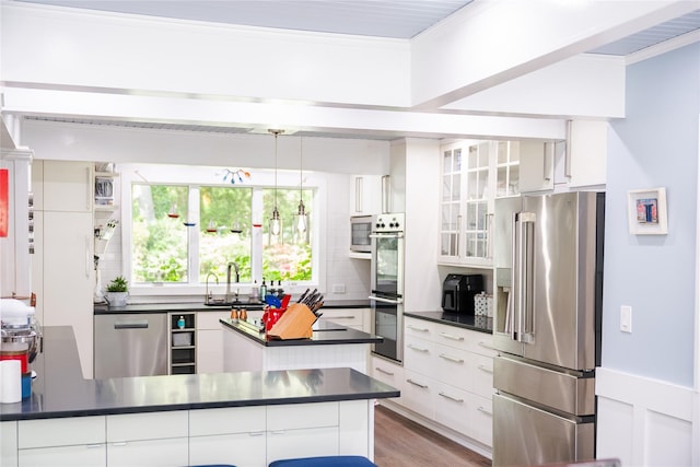 2 Spring Hollow Rd, Centerport, NY 11721 - kitchen with appliances with stainless steel finishes, dark countertops, ornamental molding, white cabinets, and tasteful backsplash