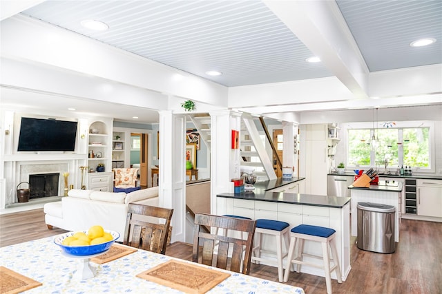 2 Spring Hollow Rd, Centerport, NY 11721 - dining room with ornate columns, wood finished floors, recessed lighting, a fireplace, and beamed ceiling