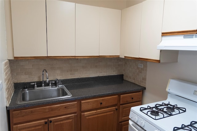 kitchen featuring ventilation hood, a sink, tasteful backsplash, white cabinetry, and white range with gas cooktop