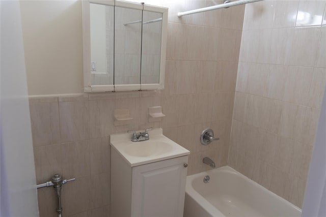 bathroom with washtub / shower combination, tile walls, and vanity