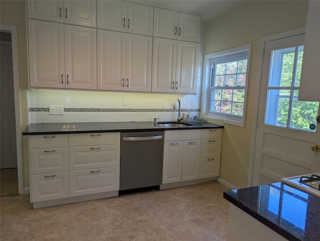 kitchen featuring a sink, dark stone counters, dishwasher, and white cabinets