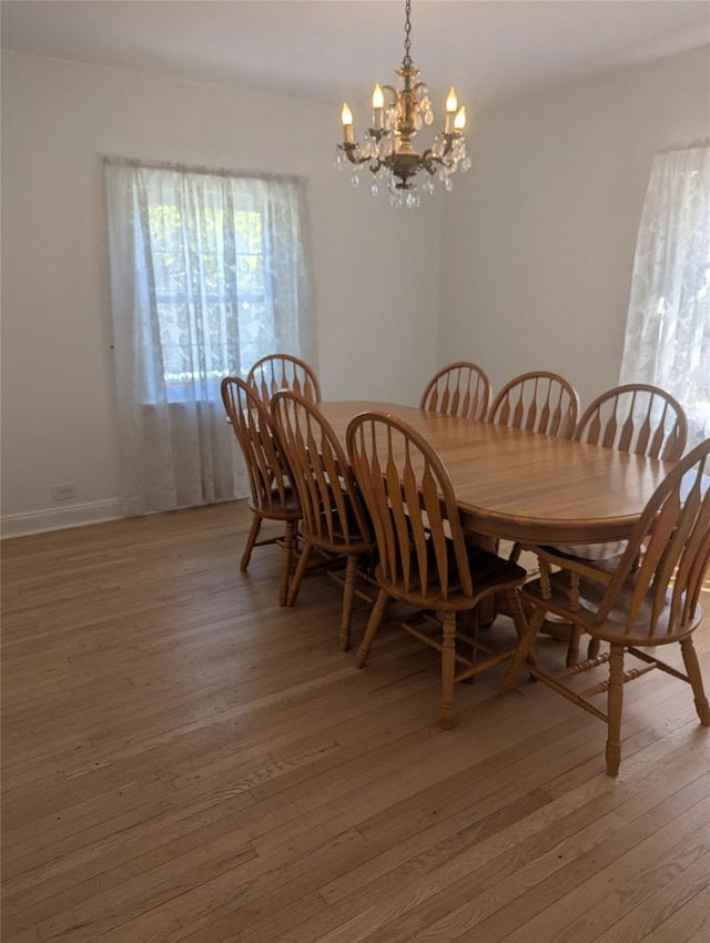 dining space featuring a notable chandelier and light wood finished floors