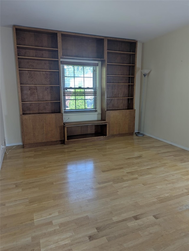 unfurnished room featuring baseboards and wood finished floors