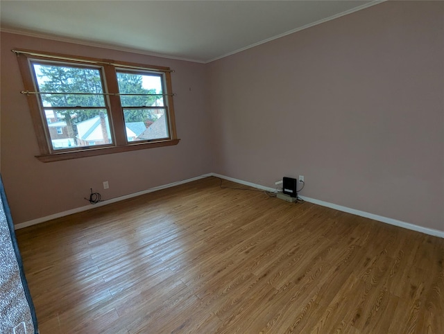 unfurnished room with crown molding, baseboards, and light wood finished floors
