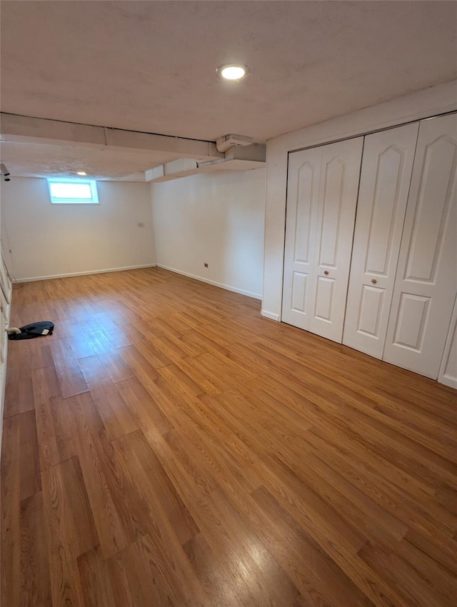 below grade area with baseboards and light wood finished floors