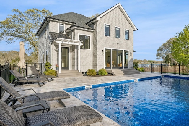 back of property with a patio, a fenced in pool, and fence