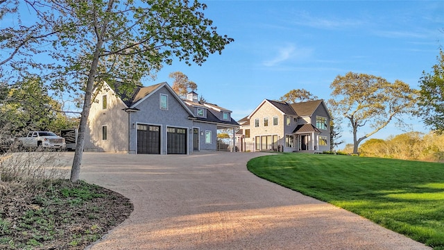 view of front of home with an attached garage, driveway, and a front yard