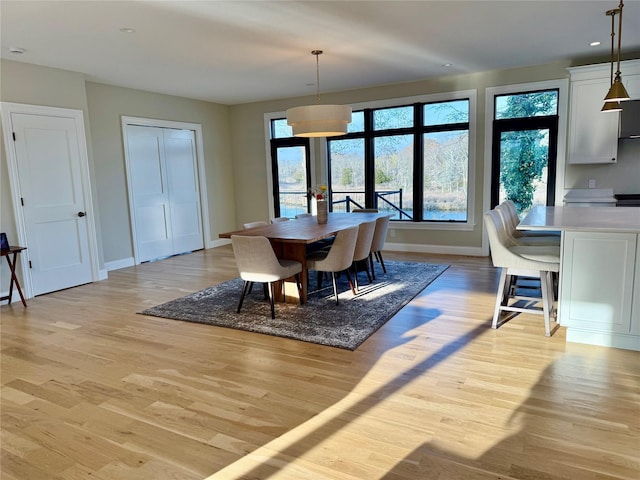 dining space with recessed lighting, baseboards, and light wood finished floors