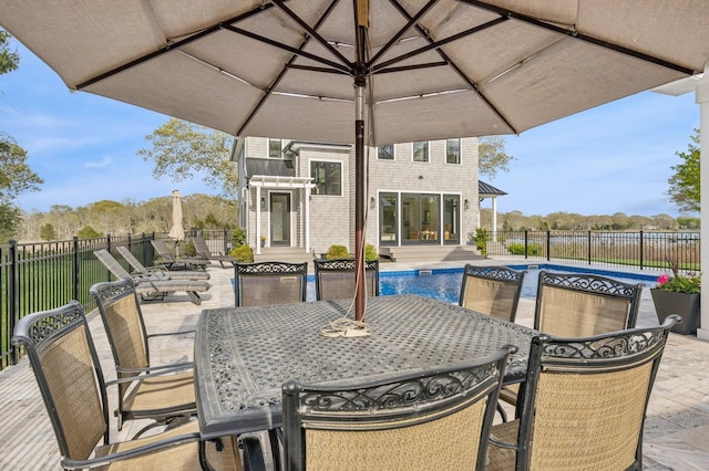 view of patio featuring a fenced in pool, outdoor dining space, and a fenced backyard