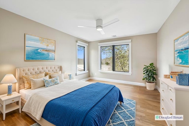 bedroom featuring a ceiling fan, baseboards, and light wood finished floors