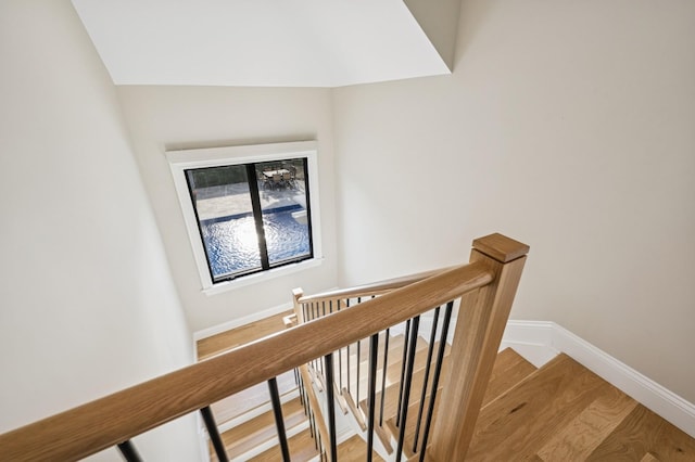 stairway featuring baseboards and wood finished floors