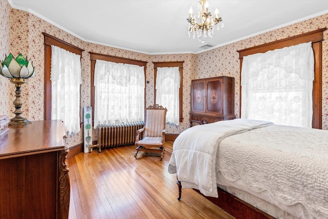 bedroom with radiator heating unit, light wood finished floors, crown molding, and wallpapered walls