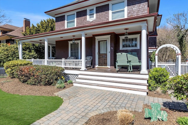 farmhouse inspired home with a porch and fence