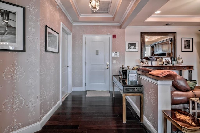 entryway featuring dark wood finished floors, baseboards, ornamental molding, and a raised ceiling