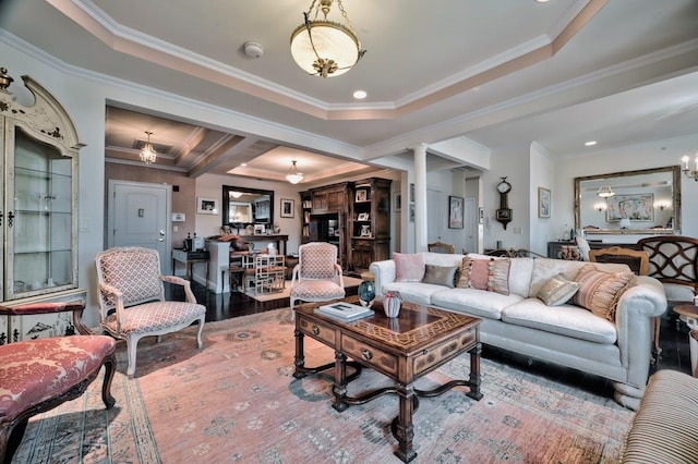 living room featuring wood finished floors, crown molding, and ornate columns