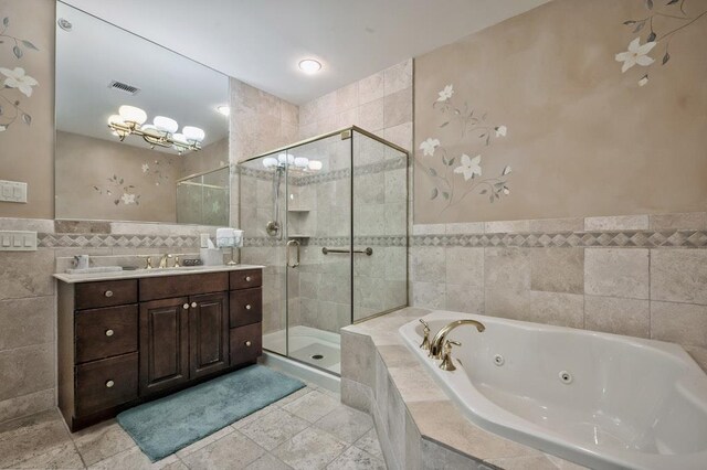 bathroom featuring a shower stall, vanity, tile walls, a jetted tub, and visible vents