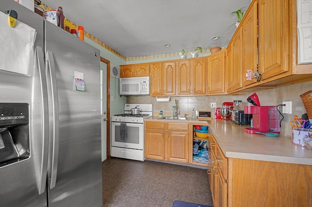kitchen with white appliances, light countertops, brown cabinets, tasteful backsplash, and a sink