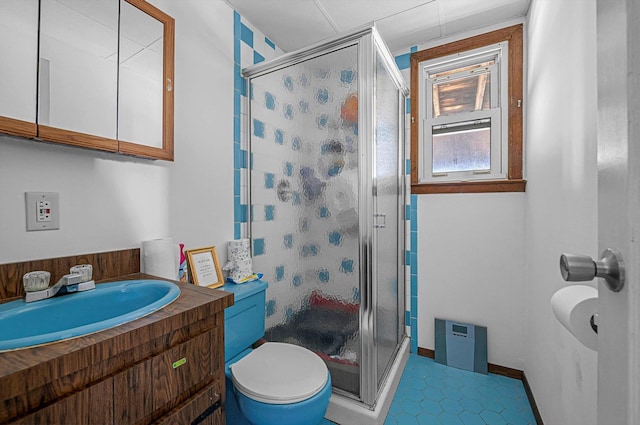bathroom featuring vanity, toilet, tile patterned floors, and a stall shower